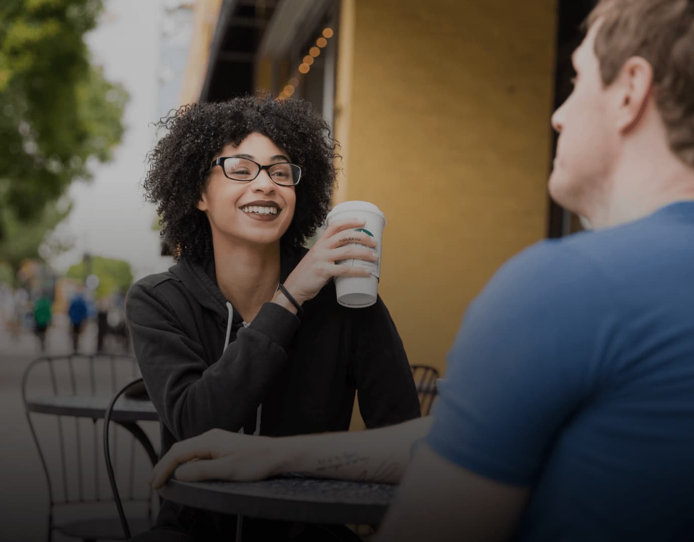 woman and man talking outside of a coffee shop